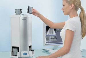 Assistente odontoiatrica utilizza un sistema digitale VistaScan per la radiografia endorale, con immagini dentali visualizzate sul monitor del computer.
